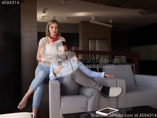 Image of Young couple on the sofa watching television