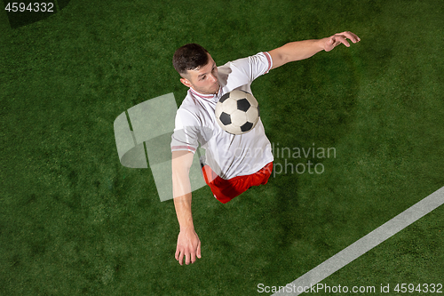 Image of Football player tackling ball over green grass background