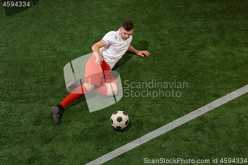 Image of Football player tackling ball over green grass background