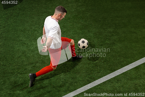 Image of Football player tackling ball over green grass background