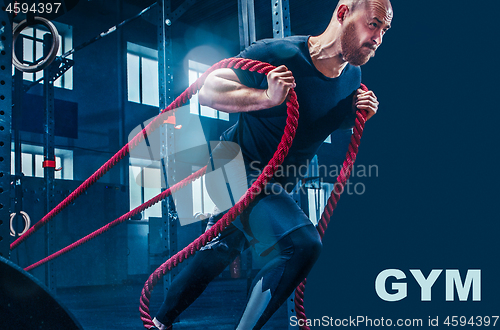 Image of Men with battle rope battle ropes exercise in the fitness gym.