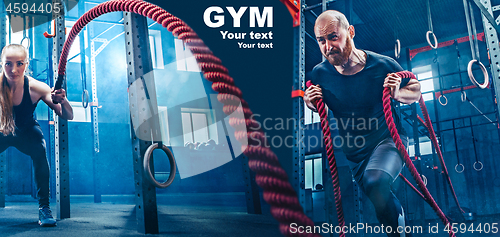 Image of Men with battle rope battle ropes exercise in the fitness gym.