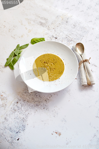 Image of Creamy soup with green pea in a ceramic white plate