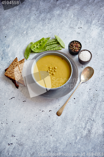 Image of Green pea cream soup in grey bowl