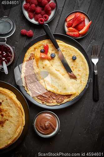 Image of Delicious chocolate homemade pancakes on black ceramic plate