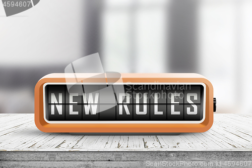 Image of New rules alarm message on a wooden desk