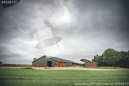 Image of Farm under a cloudy sky with green fields