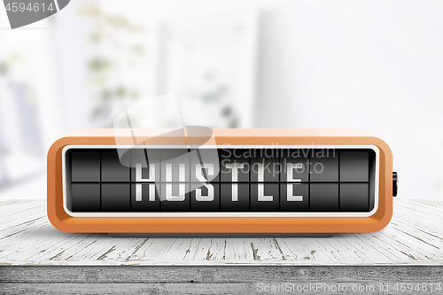 Image of Hustle alarm on a wooden table in a bright room