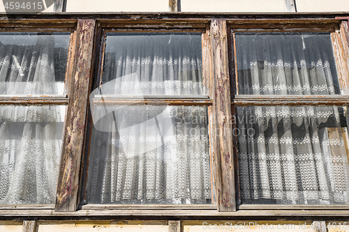 Image of Worn old windows with vintage curtains