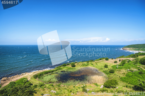 Image of Green area by the blue sea with waves