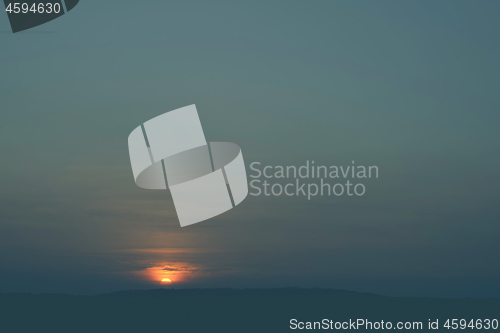 Image of Sunrise over hills covered with trees