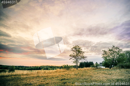 Image of Sunset over a countryside landscape with a small house