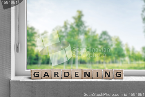 Image of View to a garden in the spring with a gardening sign