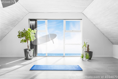 Image of Indoor yoga scene with a blue mat in a bright room