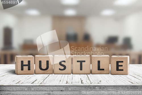 Image of Hustle sign with text on a worn desk