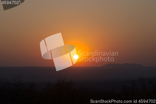 Image of Red sunset over a large area with hills