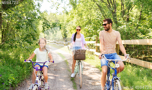 Image of happy family with bicycles in summer park