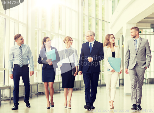 Image of business people walking along office building