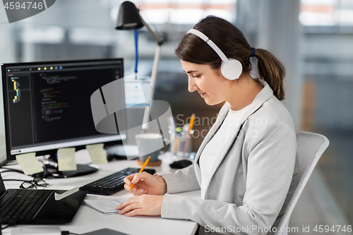 Image of businesswoman with notebook working at office