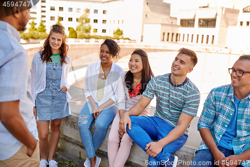 Image of happy international friends talking in city