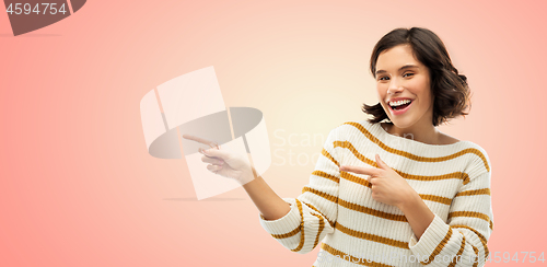 Image of happy smiling woman pointing fingers to something