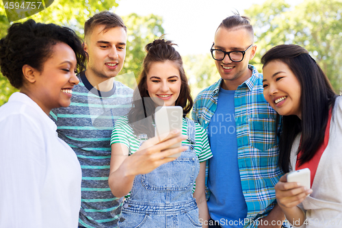 Image of happy friends with smartphone at summer park