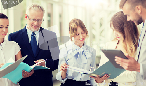 Image of business team with tablet pc and folders at office