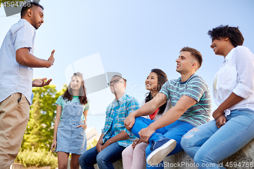 Image of happy international friends talking in city