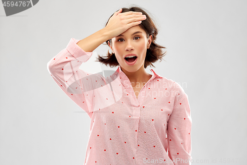 Image of confused young woman in pajama