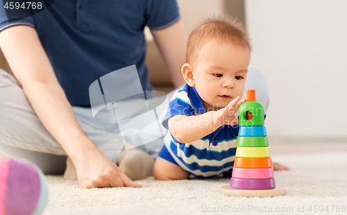 Image of baby boy with father and pyramid toy at home