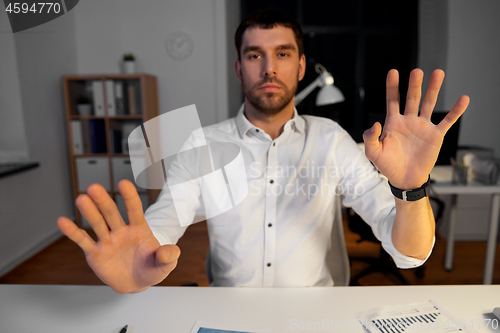 Image of businessman using gestures at night office