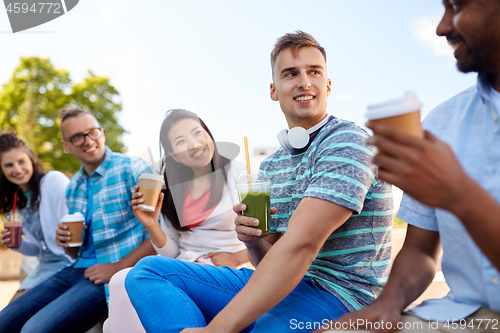 Image of friends drinking coffee and juice talking in city