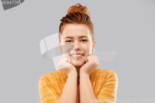 Image of smiling red haired teenage girl in checkered shirt