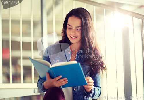 Image of high school student girl reading book at library