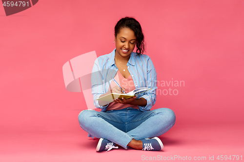 Image of african student woman writing to diary or notebook