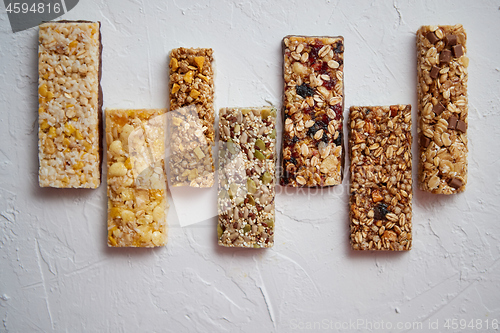 Image of Row of mixed gluten free granola cereal energy bars. With dried fruits and nuts.