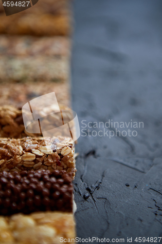 Image of Row of mixed gluten free granola cereal energy bars. With dried fruits and nuts.
