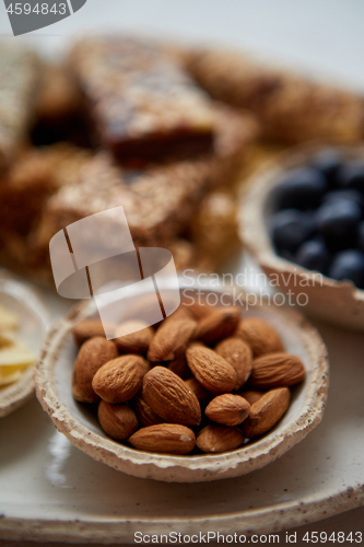 Image of Close up of whole Almonds. With various energy nutrition bars in background