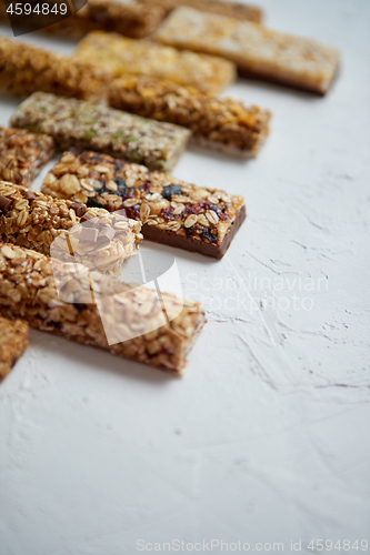 Image of Row of mixed gluten free granola cereal energy bars. With dried fruits and nuts.