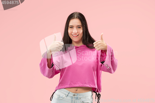 Image of The happy business woman standing and smiling against pink background.