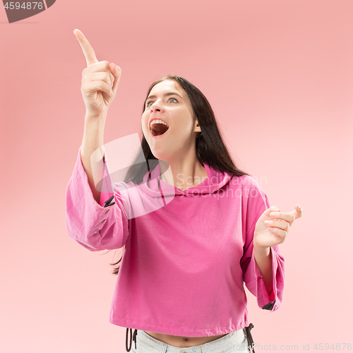 Image of Beautiful woman looking suprised isolated on pink