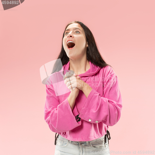 Image of Beautiful woman looking suprised isolated on pink