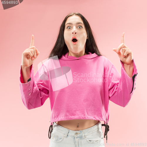 Image of Beautiful woman looking suprised isolated on pink