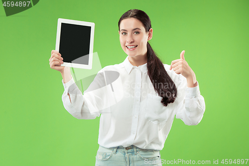 Image of Portrait of a confident casual girl showing blank screen of laptop isolated over green background