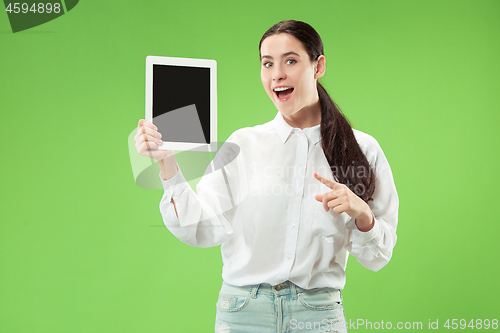 Image of Portrait of a confident casual girl showing blank screen of laptop isolated over green background