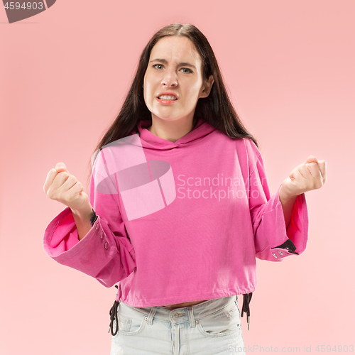 Image of Beautiful female half-length portrait isolated on pink studio backgroud. The young emotional surprised woman
