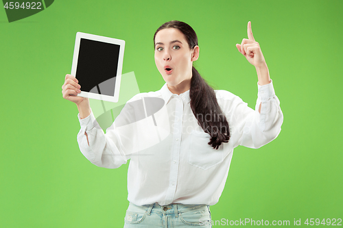 Image of Portrait of a confident casual girl showing blank screen of laptop isolated over green background