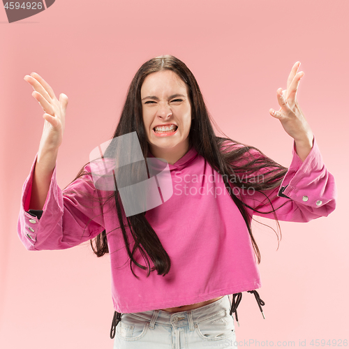 Image of Beautiful female half-length portrait isolated on pink studio backgroud. The young emotional surprised woman