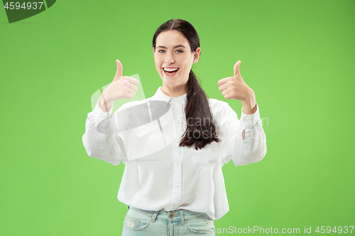 Image of The happy business woman standing and smiling against green background.