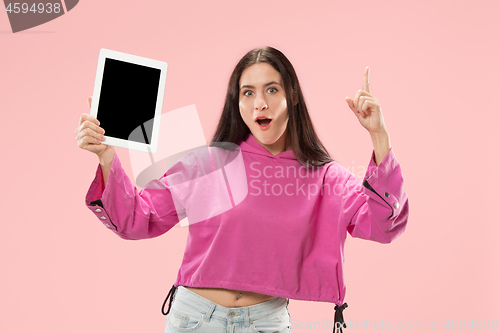 Image of Portrait of a confident casual girl showing blank screen of laptop isolated over pink background